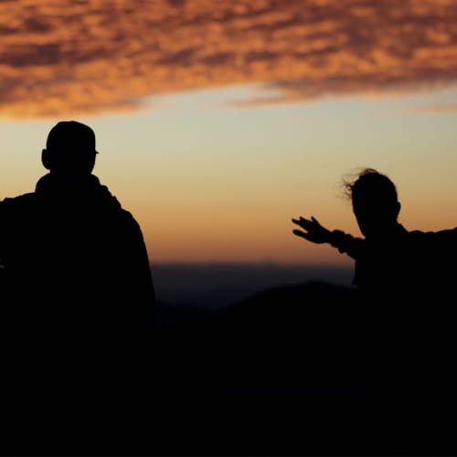 Observation du coucher de soleil en montagne après une randonnée